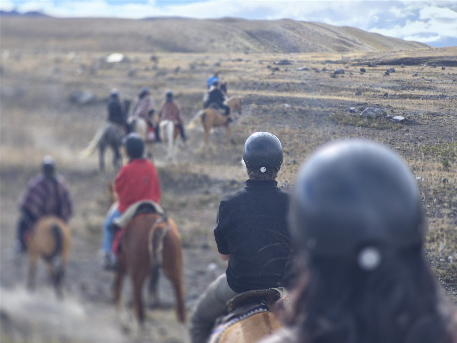 Riders crossing the open Cotopaxi páramo on horseback